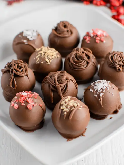 Delicious homemade chocolate cream cheese truffles topped with colorful sprinkles.