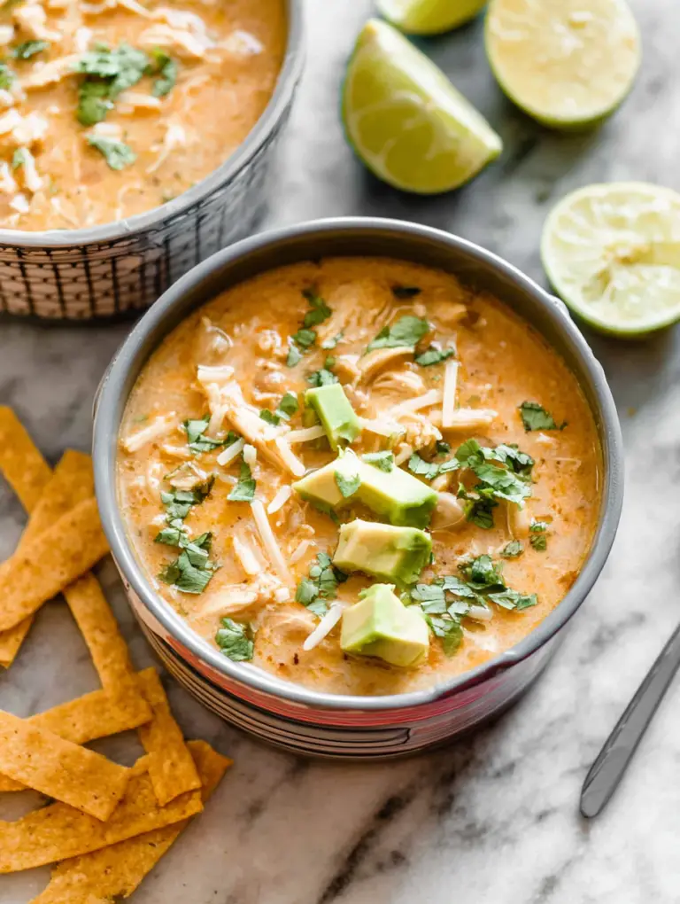 A bowl of creamy white chicken chili with cilantro and avocado slices, perfect comfort food for chilly nights.