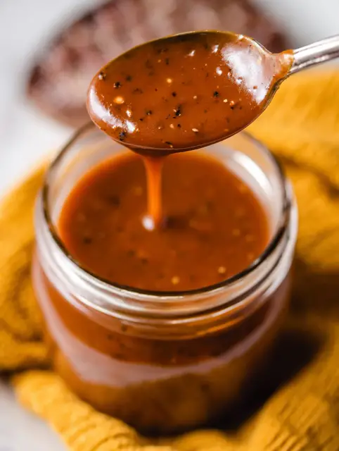 Juicy steak topped with homemade Texas Roadhouse steak sauce, garnished with fresh herbs.