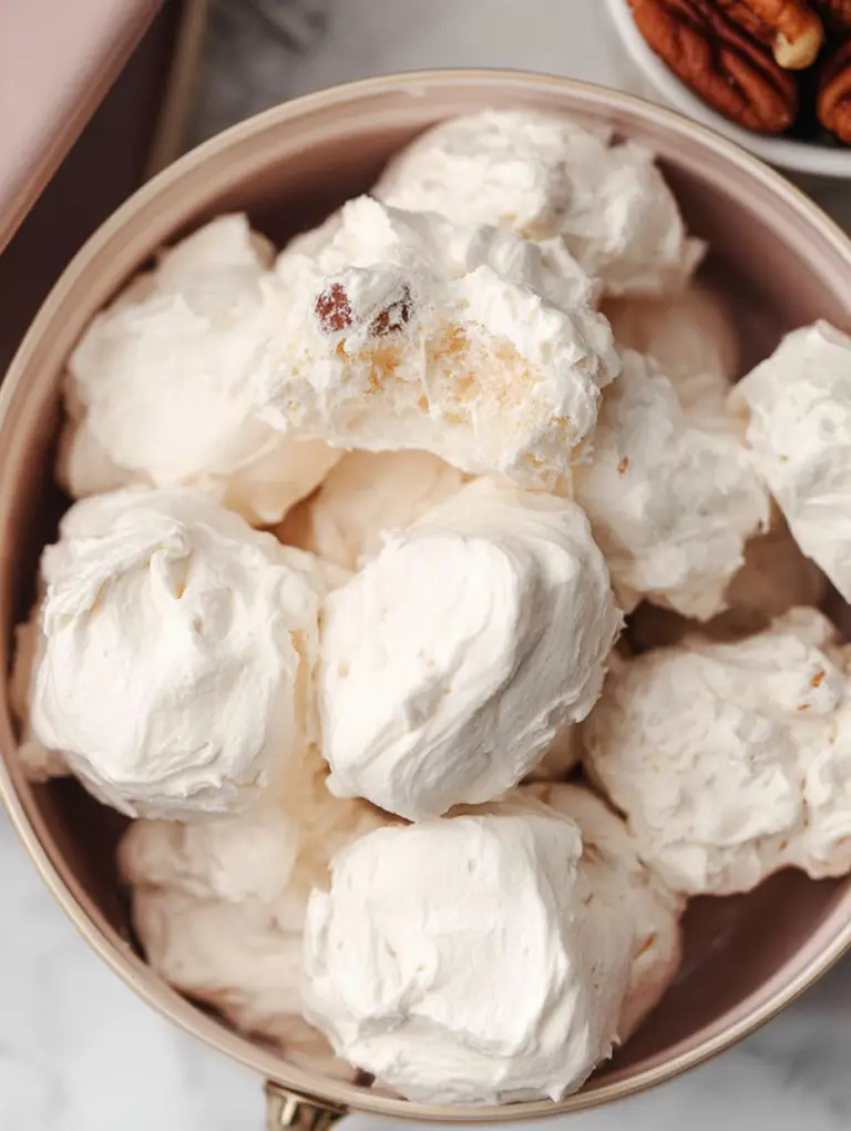 Close-up view of old-fashioned divinity candy on a vintage plate with pecans.