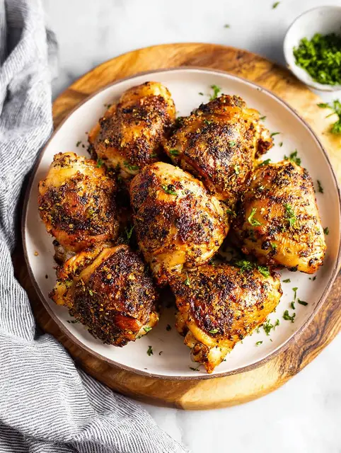 Juicy oven baked chicken thighs served with vibrant roasted vegetables and fresh herbs.