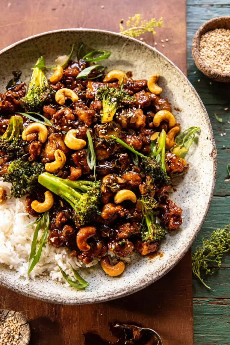 Garlic butter cashew chicken served on rice with broccoli and sesame seeds.