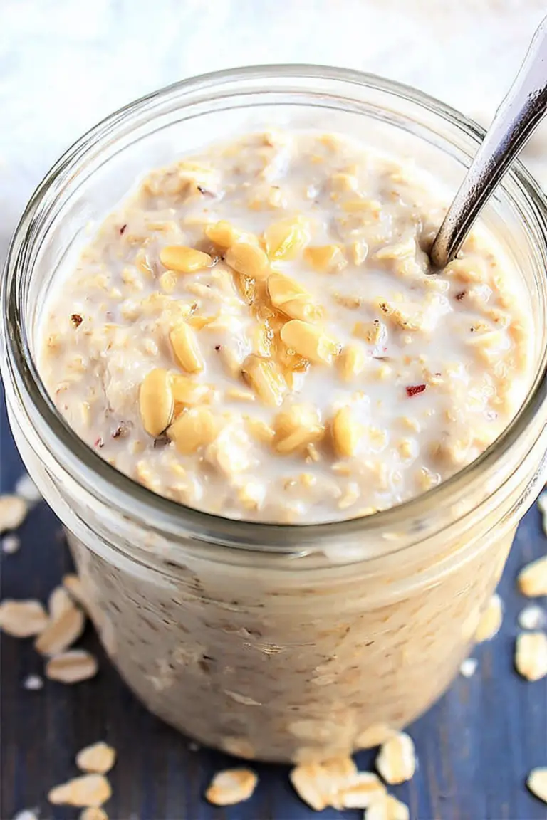 Delicious basic overnight oats topped with fresh berries and nuts in a jar on a wooden table.