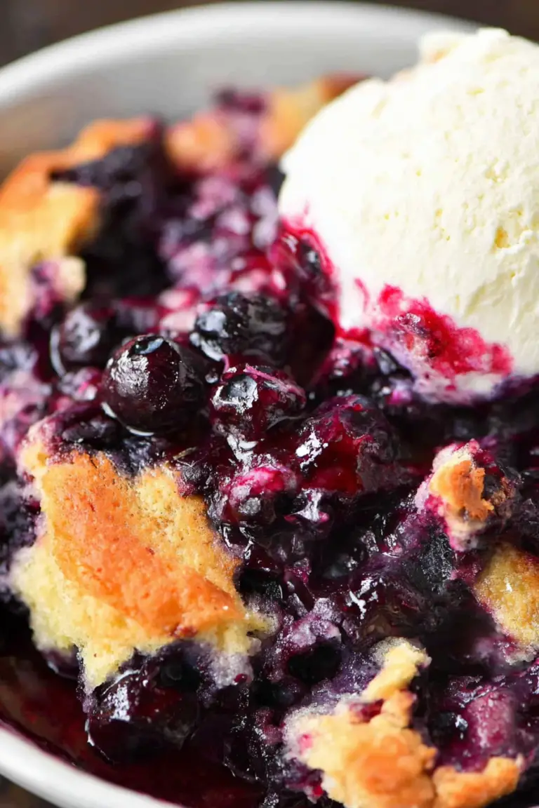 Delicious homemade blueberry cobbler with a golden-brown topping and fresh blueberries.