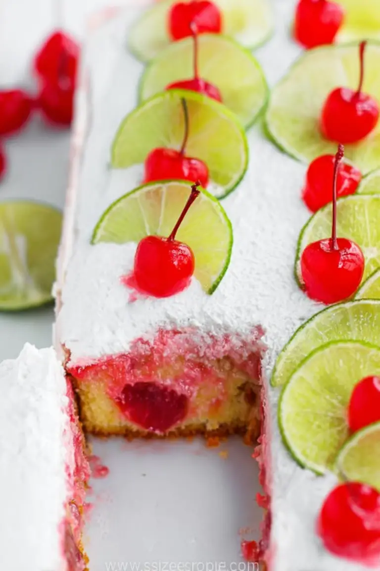 Slice of cherry limeade poke cake with lime slices and maraschino cherries on a plate