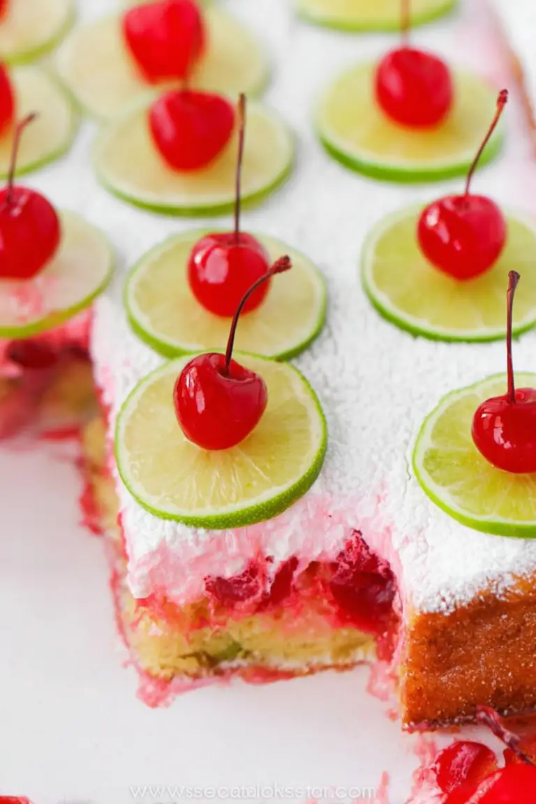 Slice of cherry limeade poke cake with whipped cream, lime slices, and cherries
