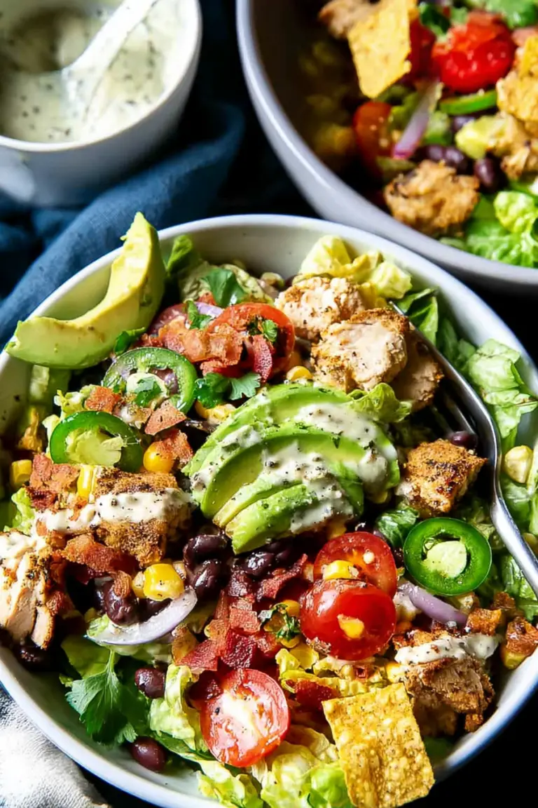 Colorful Santa Fe Salad featuring romaine lettuce, grilled chicken, black beans, corn, and avocado, served in a large bowl.