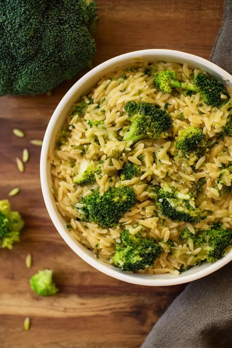 Close-up of a creamy broccoli and orzo skillet with broccoli and melted cheese.