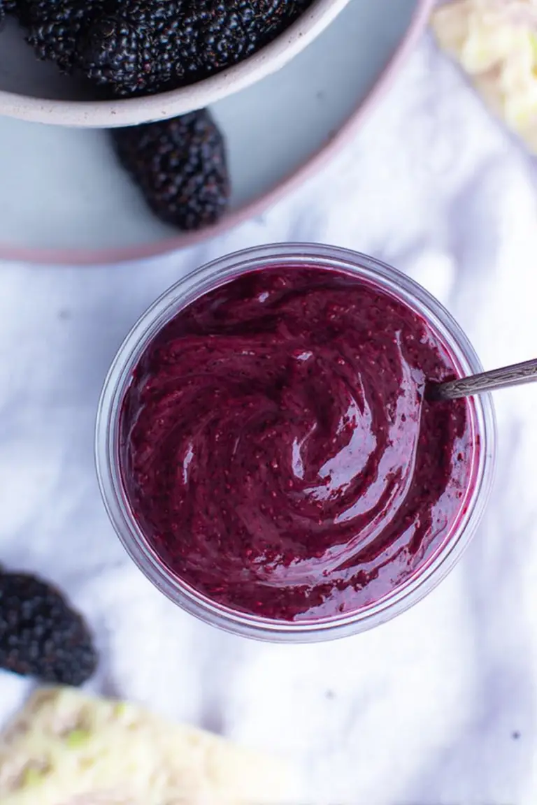 Fresh mulberry curd in a jar with fresh mulberries on a wooden table