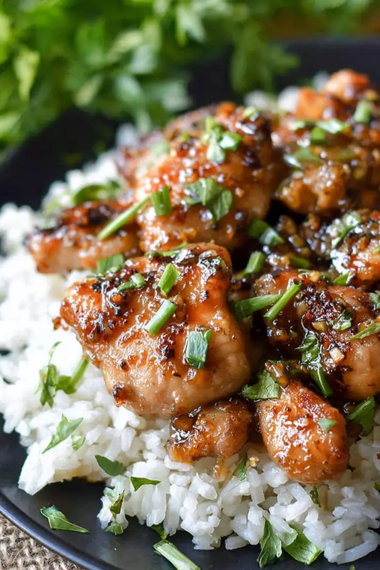 Delicious honey butter garlic chicken garnished with parsley and served with rice on a wooden table.