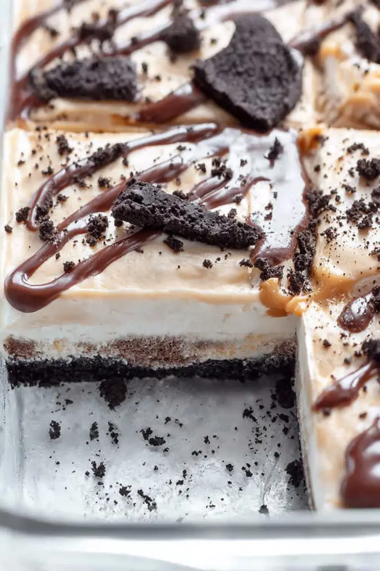 Close-up of layered Buster Bar Ice Cream Dessert with chocolate fudge and OREO cookie crust