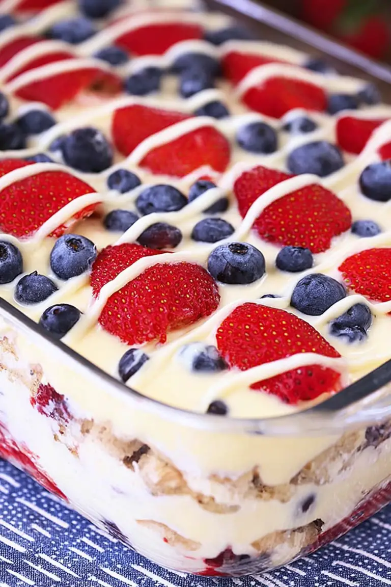 A slice of No Bake Summer Berry Icebox Cake highlighting layers of cream, strawberries, and blueberries on a plate.