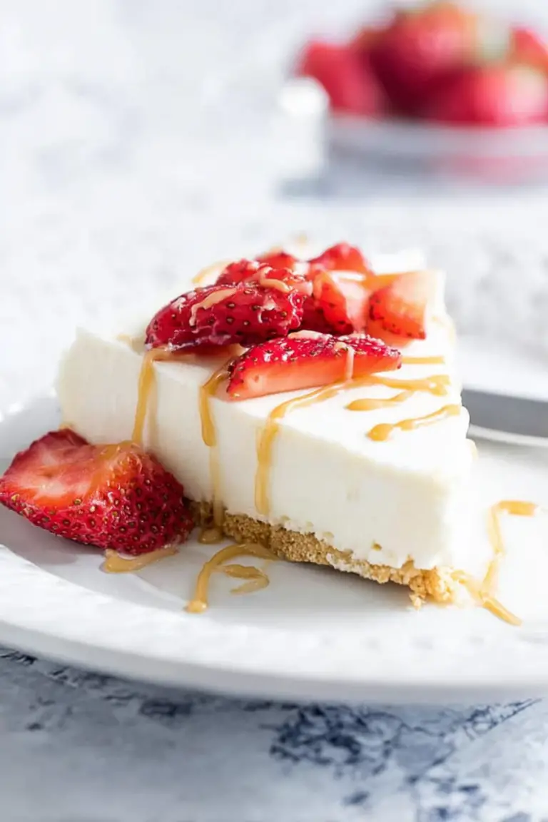 Slice of no bake vanilla cheesecake with fresh berries and caramel sauce on a wooden table.