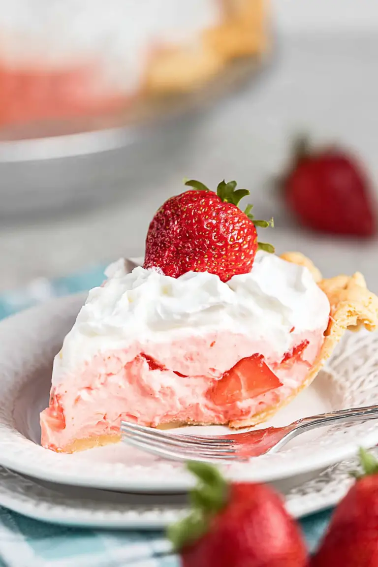 A delicious strawberry cream pie with fresh strawberries on top, showcasing a slice that reveals the creamy filling inside.