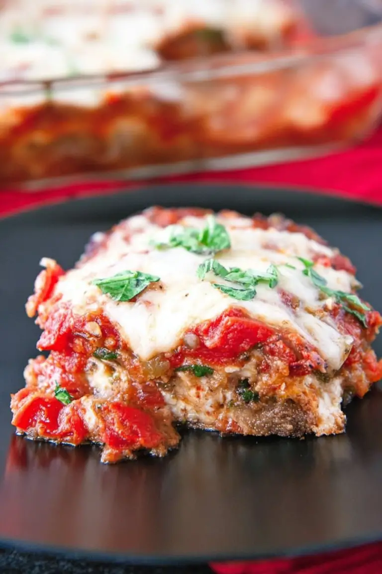 Delicious vegetarian eggplant lasagna with layers of cheese, sauce, and garnished with basil leaves.
