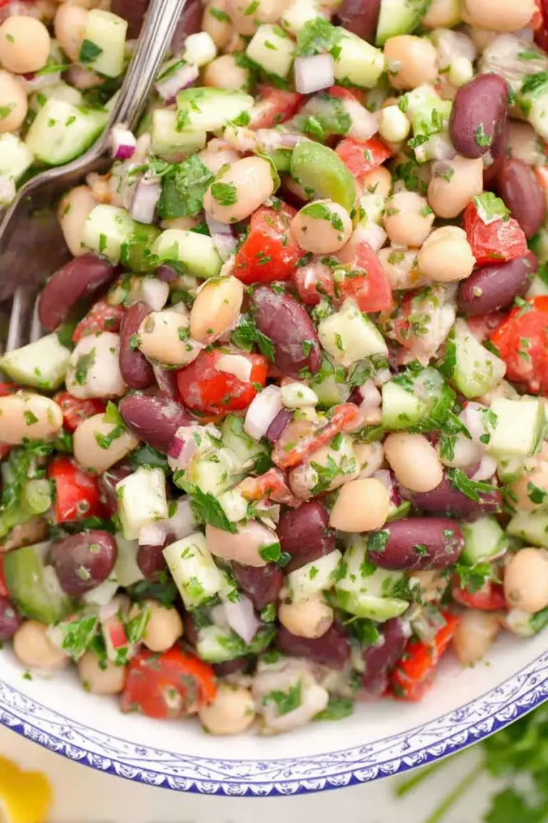 Vibrant Mediterranean bean salad filled with garbanzo beans, cannellini beans, kidney beans, and fresh vegetables in a bowl.