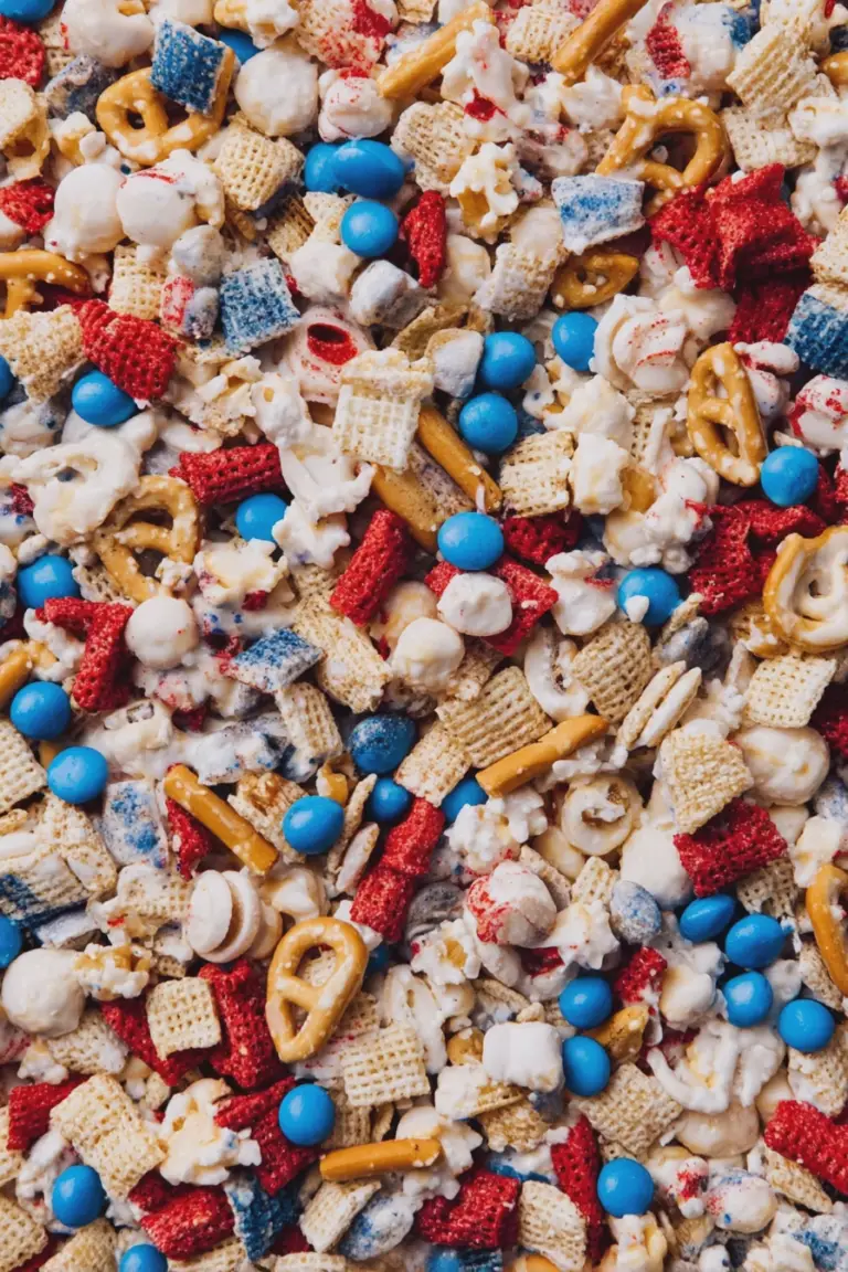 Colorful 4th of July Snack Mix in a bowl with red, white, and blue M&M's and pretzels on a summer-themed table.