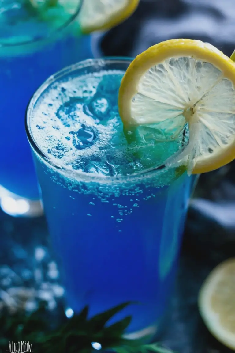 Refreshing blue lagoon mocktail with ice and lemon garnish on a summer background