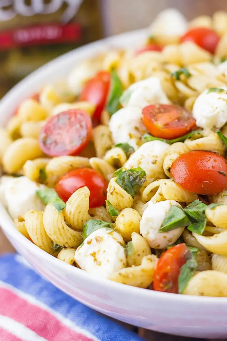 Caprese Pasta Salad with cherry tomatoes, basil, and mozzarella in a colorful bowl