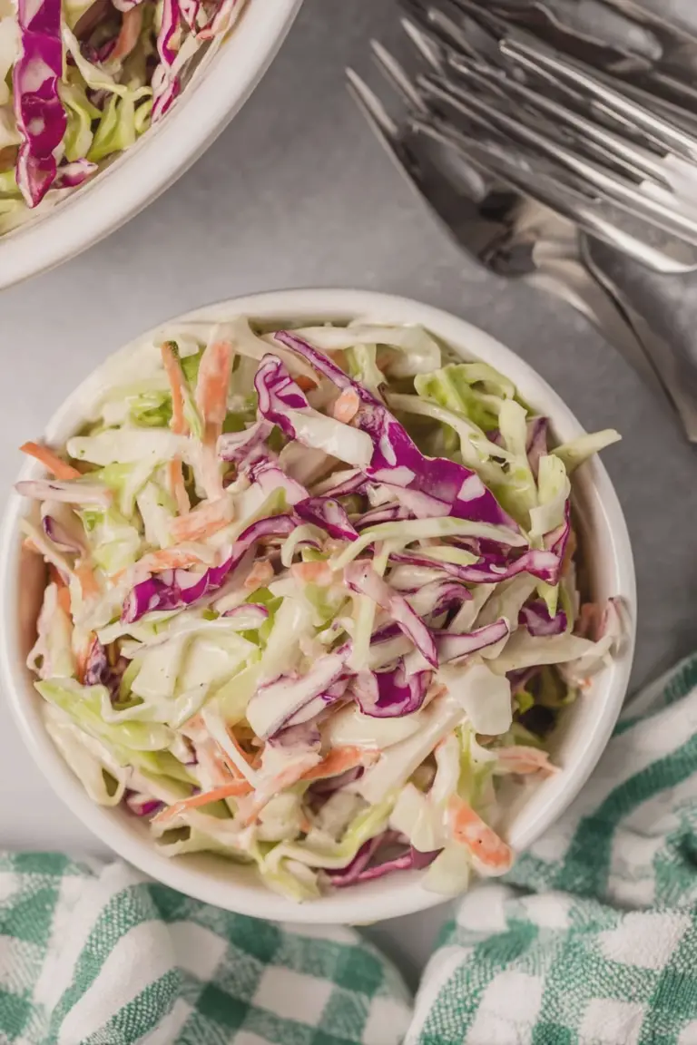 A colorful bowl of fresh coleslaw with shredded cabbage, carrots, and green onions, highlighting its crisp texture and vibrant colors.