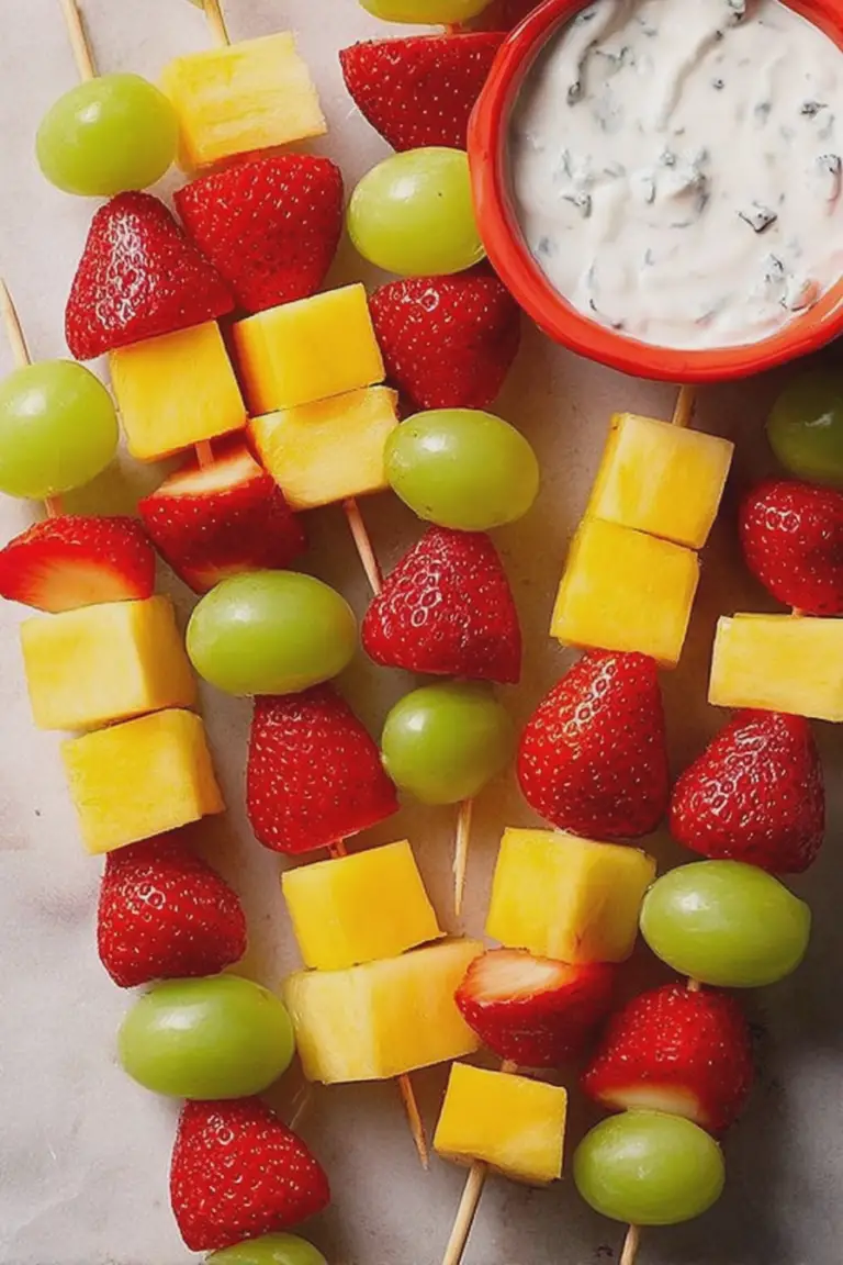 Vibrant fruit skewers with strawberries, grapes, and cheese served with cinnamon yogurt dip.