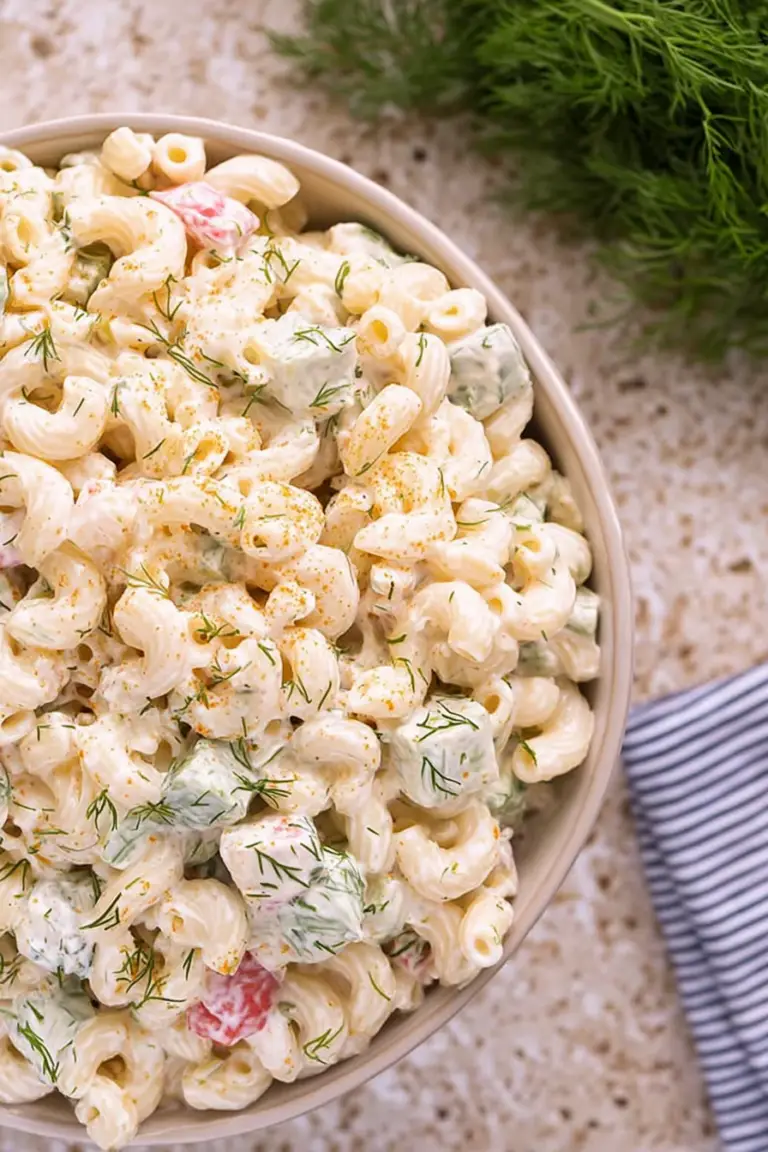 Delicious macaroni dill salad with fresh dill and radishes on a picnic table.