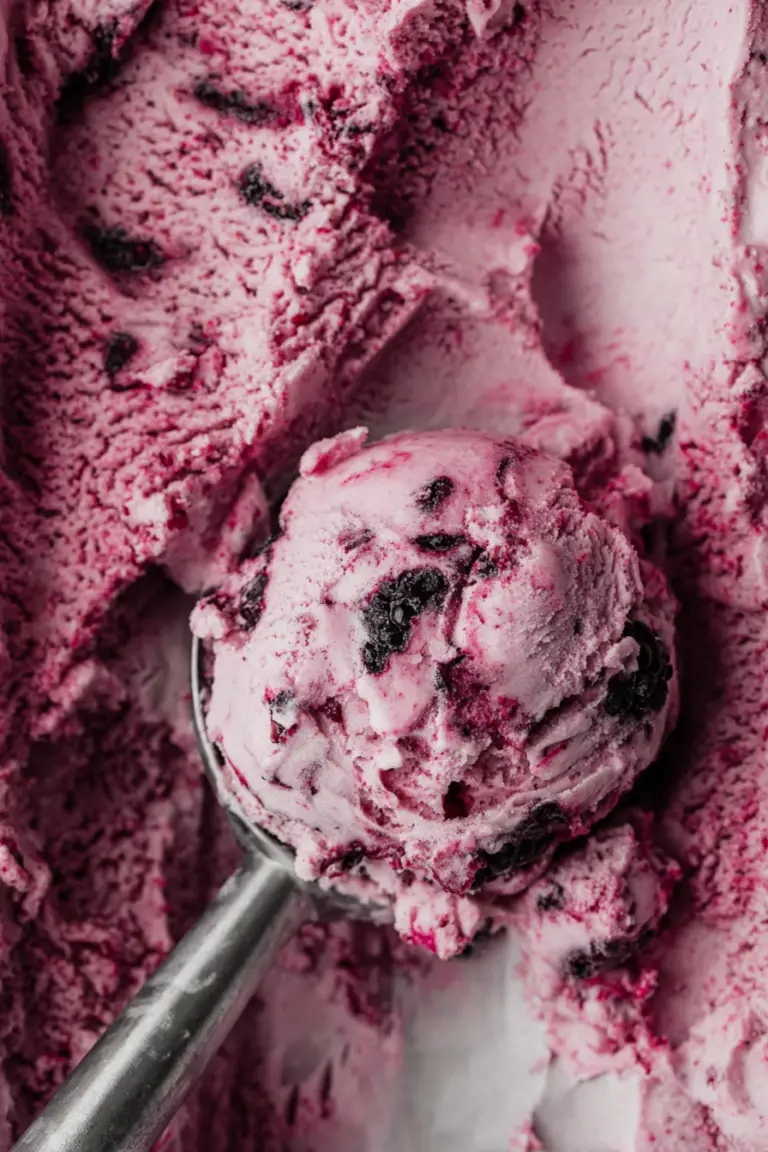 No-churn mulberry ice cream in a bowl with fresh berries and compote on top.