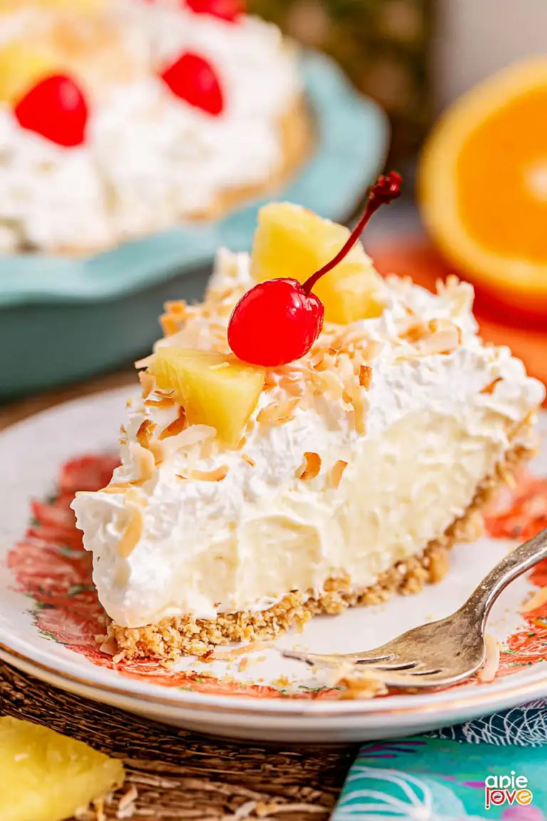 Slice of Pina Colada Pie with whipped cream, maraschino cherries, and graham cracker crust on a colorful plate outdoors.