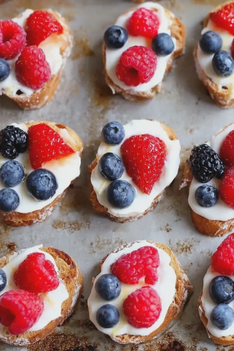 Summer berry crostini with lemon ricotta and honey served on a picnic table