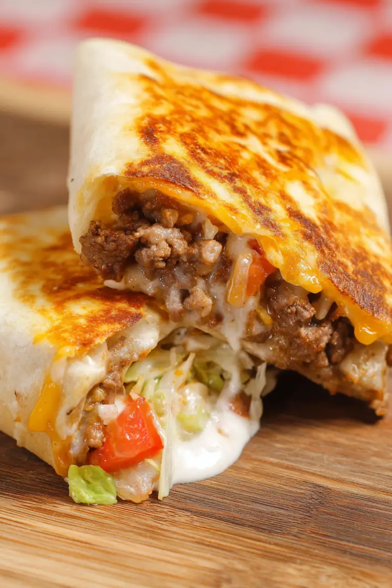 Half of a Weight Watchers Cheeseburger Crunch Wrap displaying layers of beef, cheese, and vegetables.